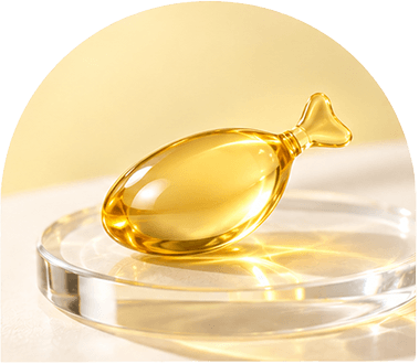 A golden omega-3 capsule on a glass dish